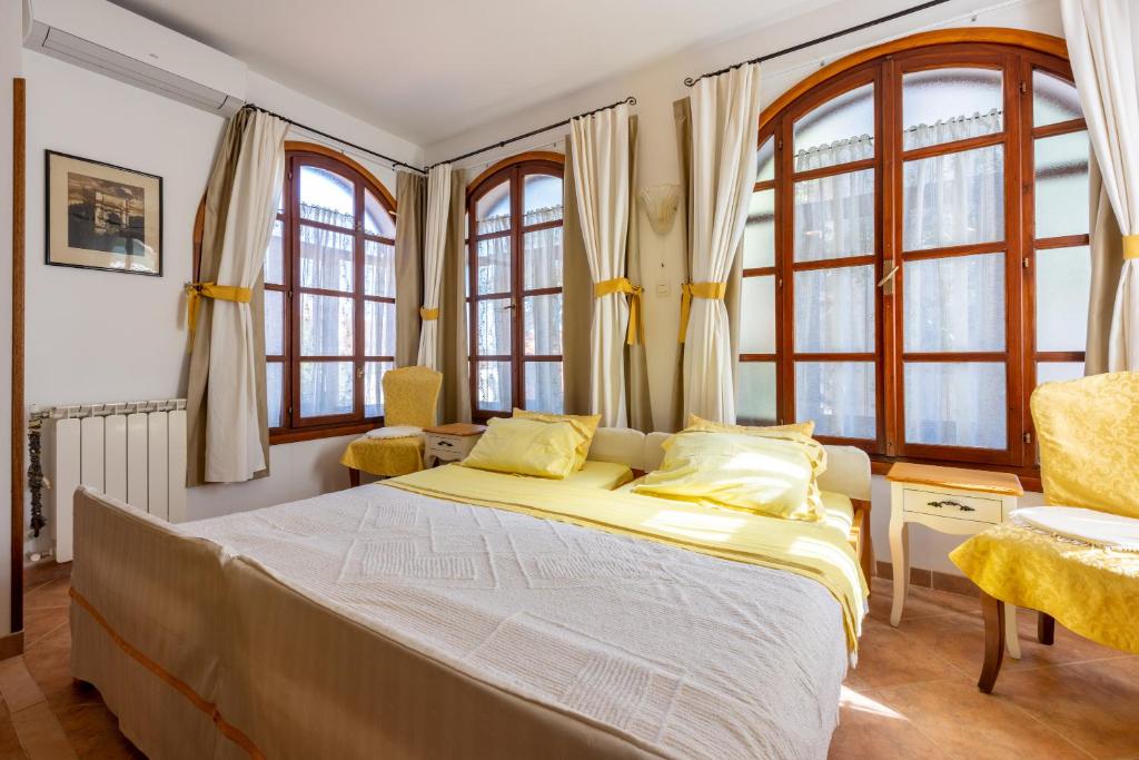 a bedroom with a large bed and windows at Apartments villa MaVeRo in Banjole