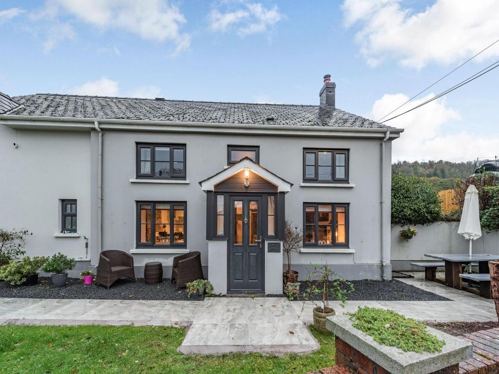 a white house with black windows and a patio at The Annex in Llanarthney