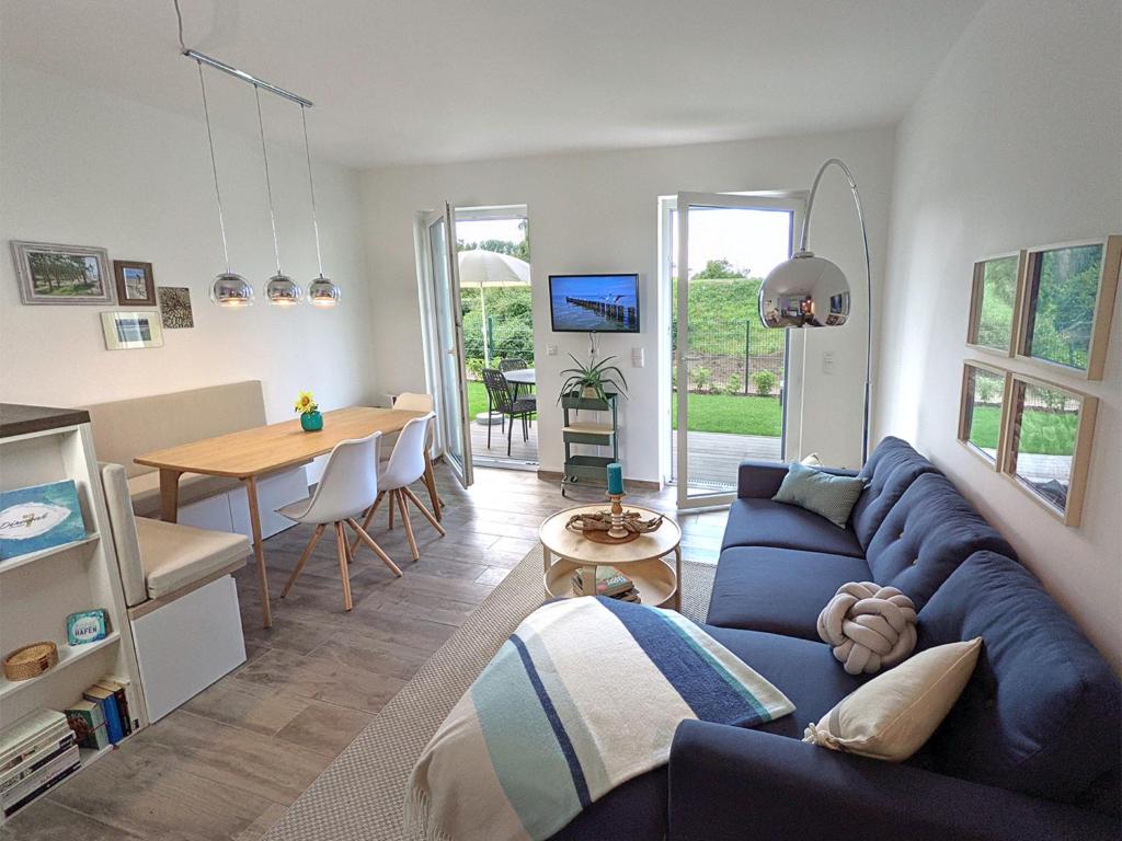 uma sala de estar com um sofá azul e uma mesa em App 7, Strandresidenz Dünenperle em Kühlungsborn