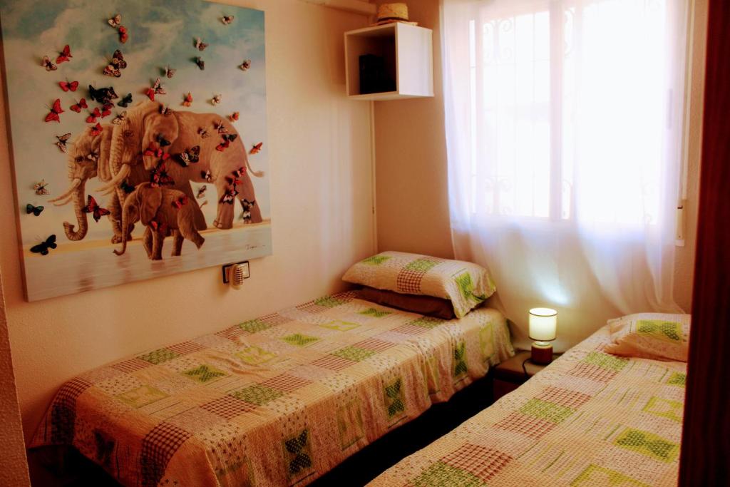 - une chambre avec 2 lits et une photo d'éléphant dans l'établissement Casa Azul, à Alicante