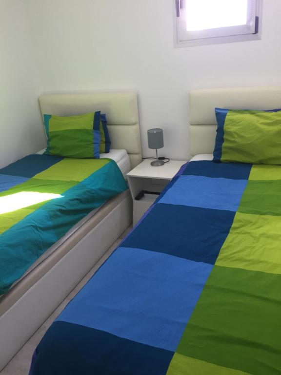 a bedroom with two beds with colorful sheets at Los Gracioseras 2 Bed Apt no 218 - AC, WIFI, UK TV in Tías
