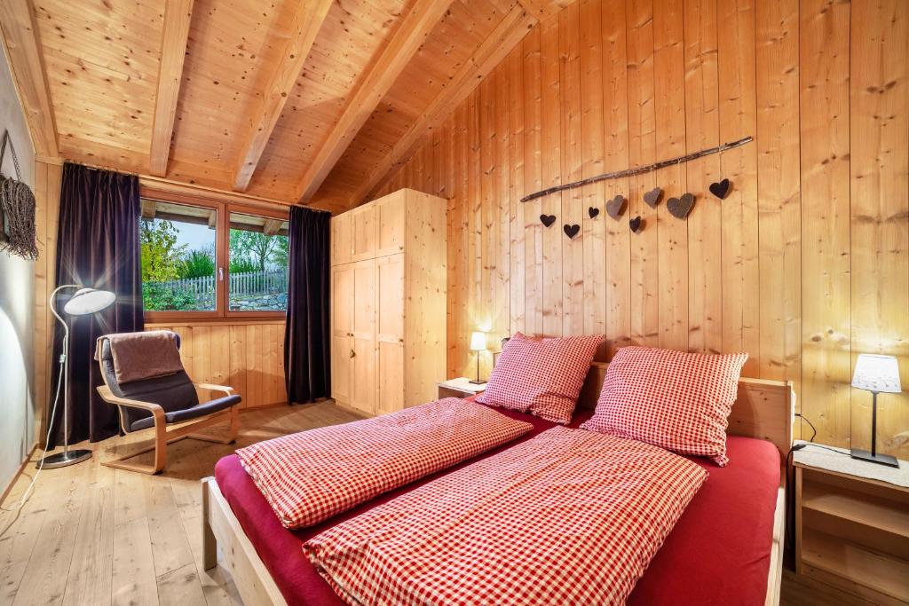 1 dormitorio con 1 cama en una habitación con paredes de madera en Grushof App Paföl, en Sluderno