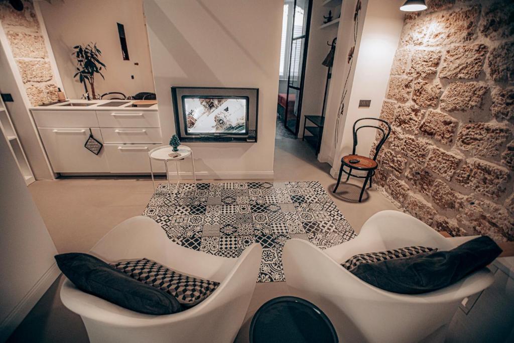 a room with two white chairs and a table at Casa 3D'Oro Palermo in Palermo