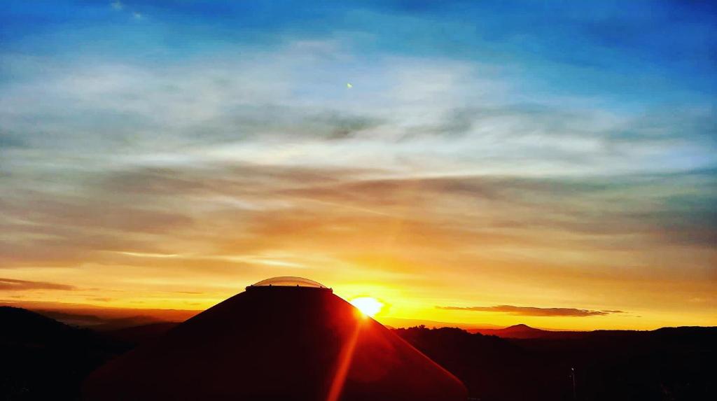 un coucher de soleil au sommet d'une montagne dans l'établissement Yourte ,volcans,randonnées,lacs,quiétude, à Grandeyrolles