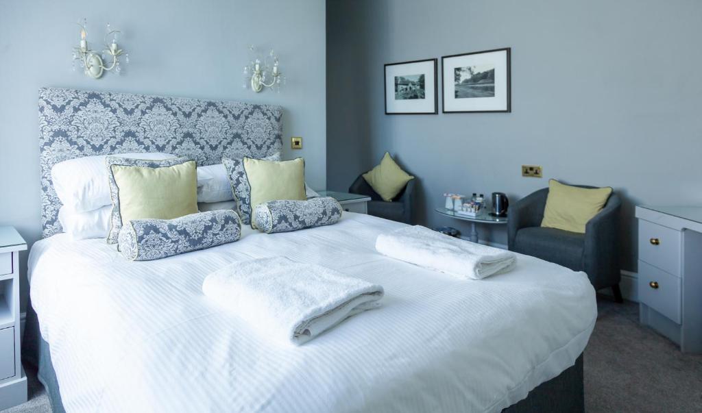 a bedroom with a large white bed with two towels on it at The Royal Hotel in Ventnor