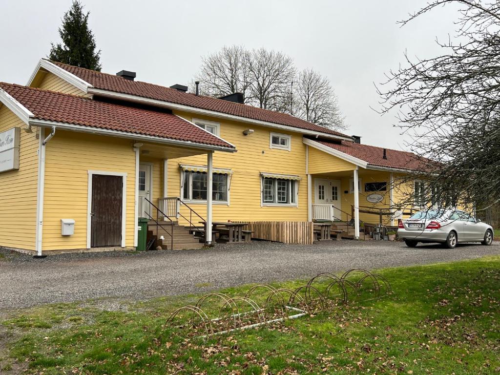 una casa amarilla con un coche aparcado delante de ella en DAG-15 en Korpo