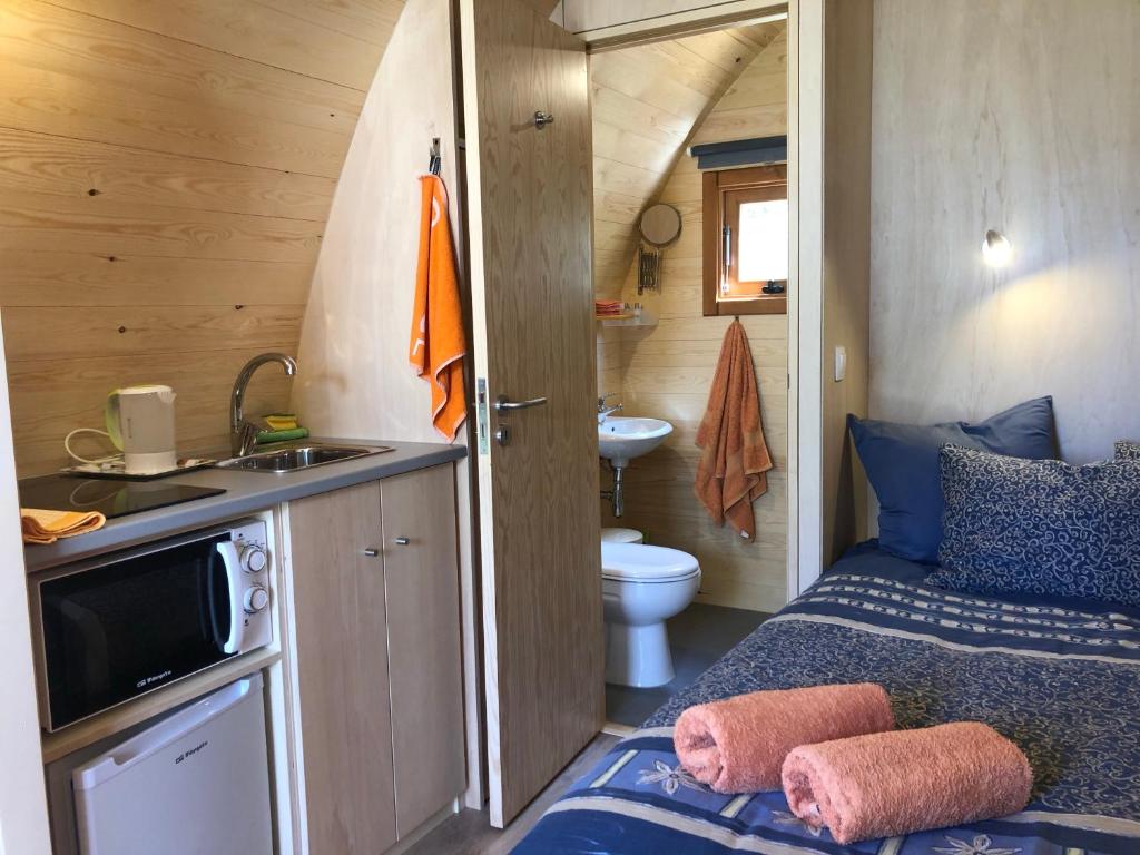 uma pequena casa de banho com uma cama numa caravana em Quinta das Cegonhas em Gouveia