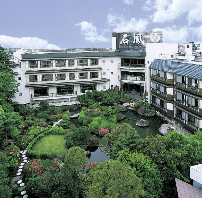 un edificio con jardín frente a un edificio en Hotel Sekifu, en Fuefuki