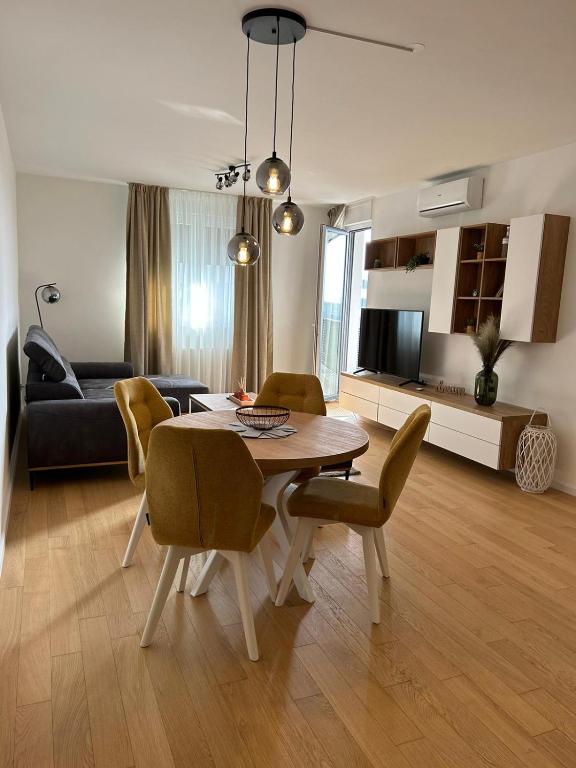 a living room with a table and chairs and a couch at Apartman ARIA in Zagreb