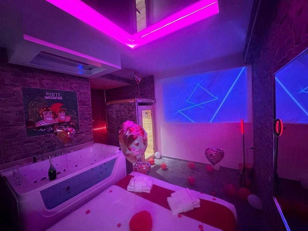 ローマにあるImperatoreのピンクの照明とハートが付いたバスタブが備わる客室です。