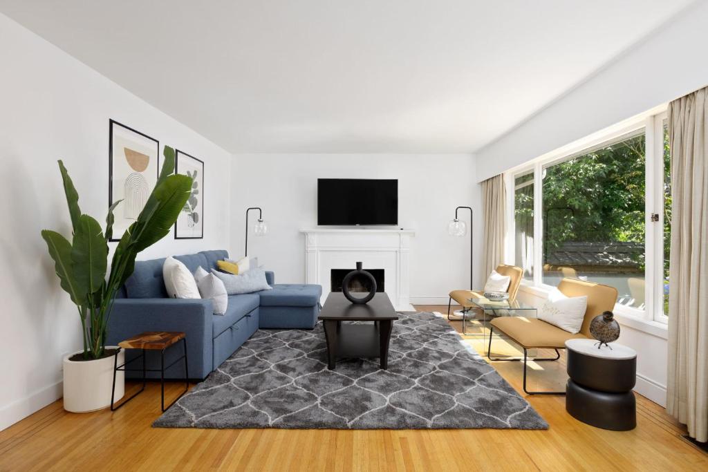 uma sala de estar com um sofá azul e uma lareira em Spacious 3 bedroom property in North Vancouver em North Vancouver