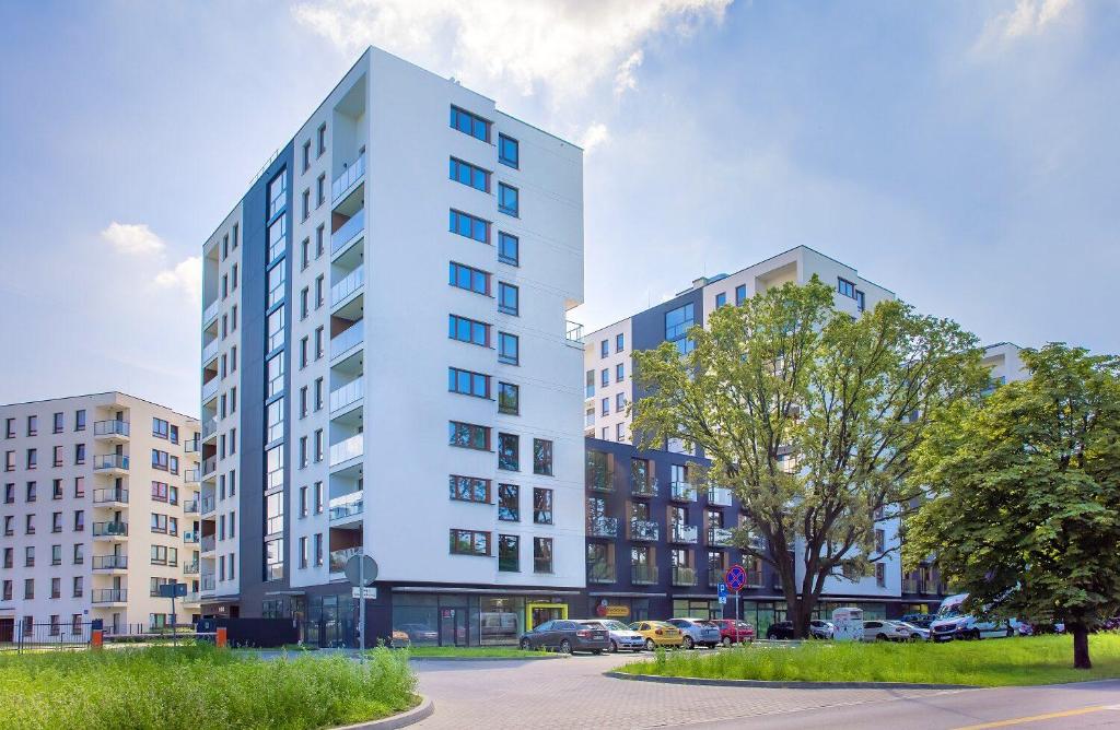 a tall white building on a city street at Metro Bielany Apartments with Parking by Renters in Warsaw