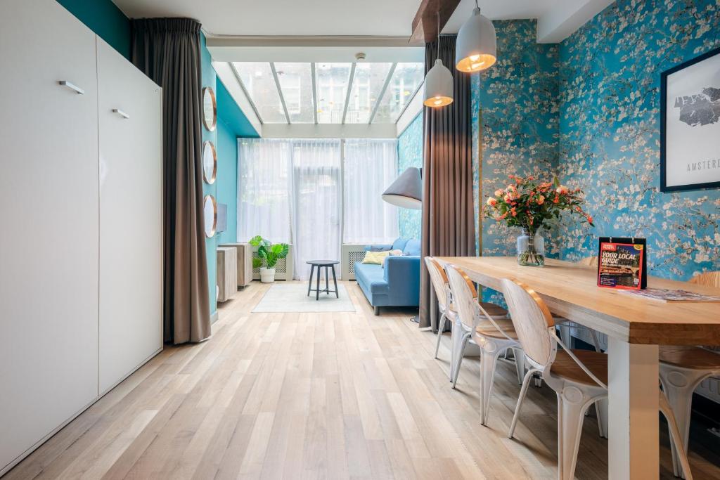 une salle à manger avec des murs bleus, une table et des chaises dans l'établissement Musea Hotel & Apartments, à Amsterdam