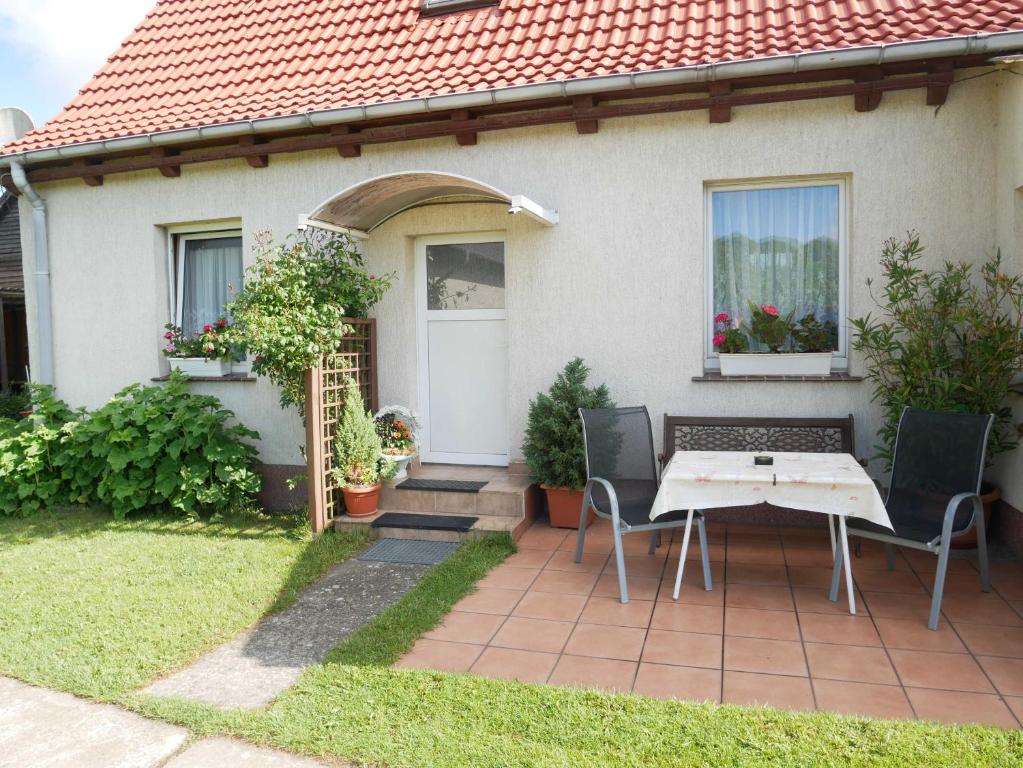 a house with a table and chairs in the yard at Ferienwohnung Kasch in Krummin