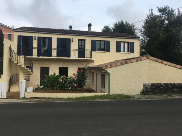 een groot geel huis met zwarte luiken op een straat bij LE TERTRE CAMILLAC 