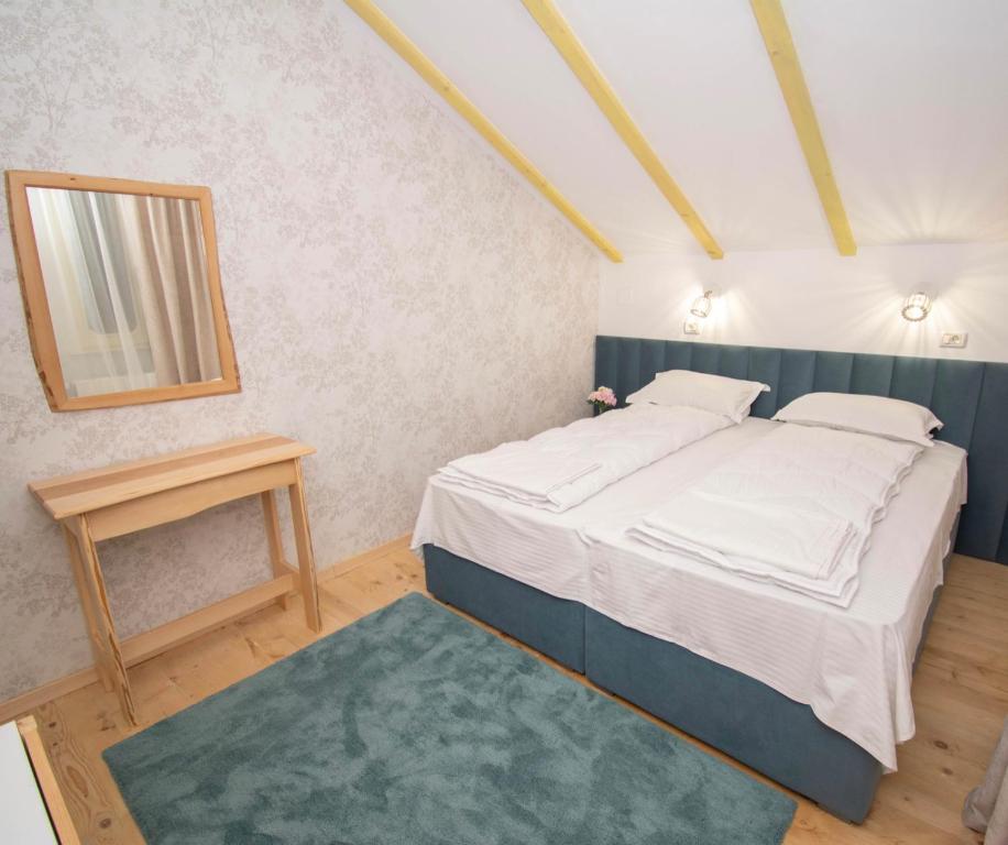 Schlafzimmer mit einem Bett, einem Tisch und einem Spiegel in der Unterkunft Natural & Simplu in Petroşani