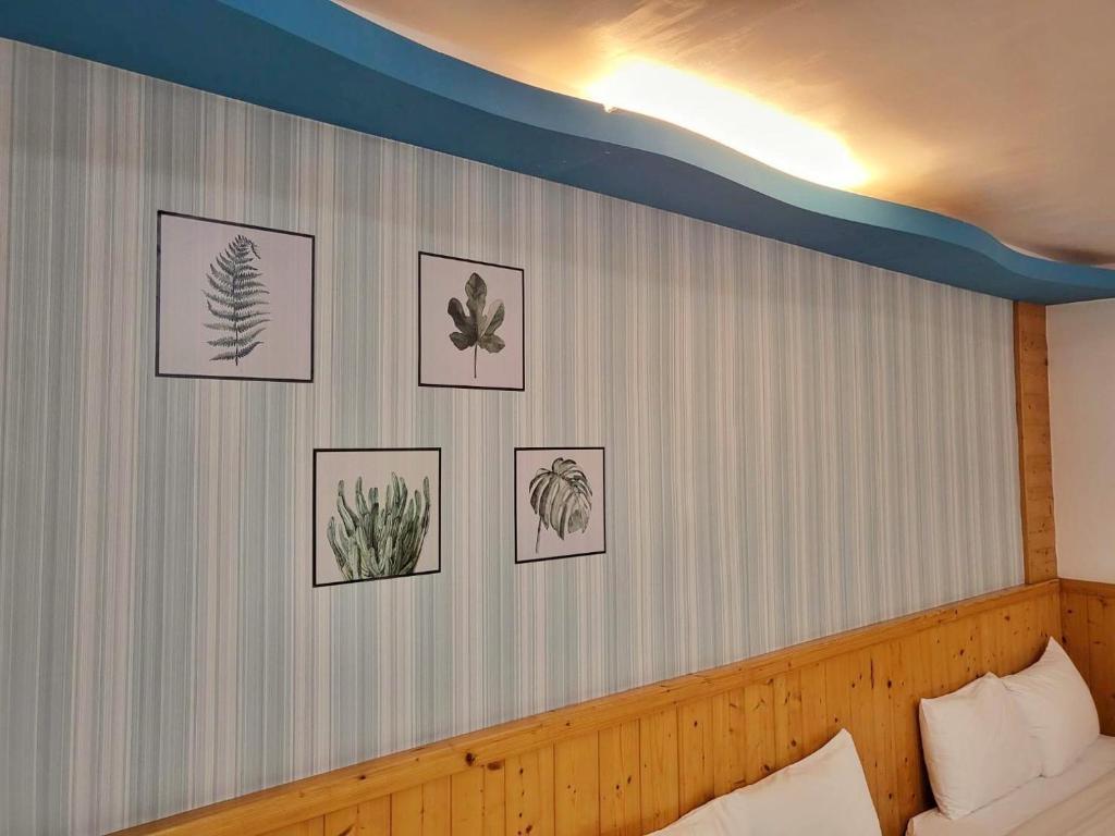 a bedroom with pictures of plants on the wall at Xing Ji Hotel in Kenting