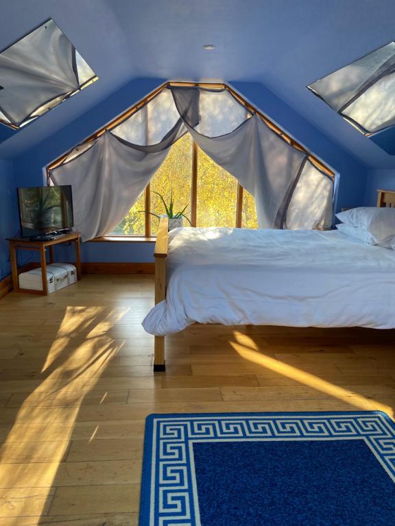 a bedroom with a bed and a window at Ralph's Barn in Newport