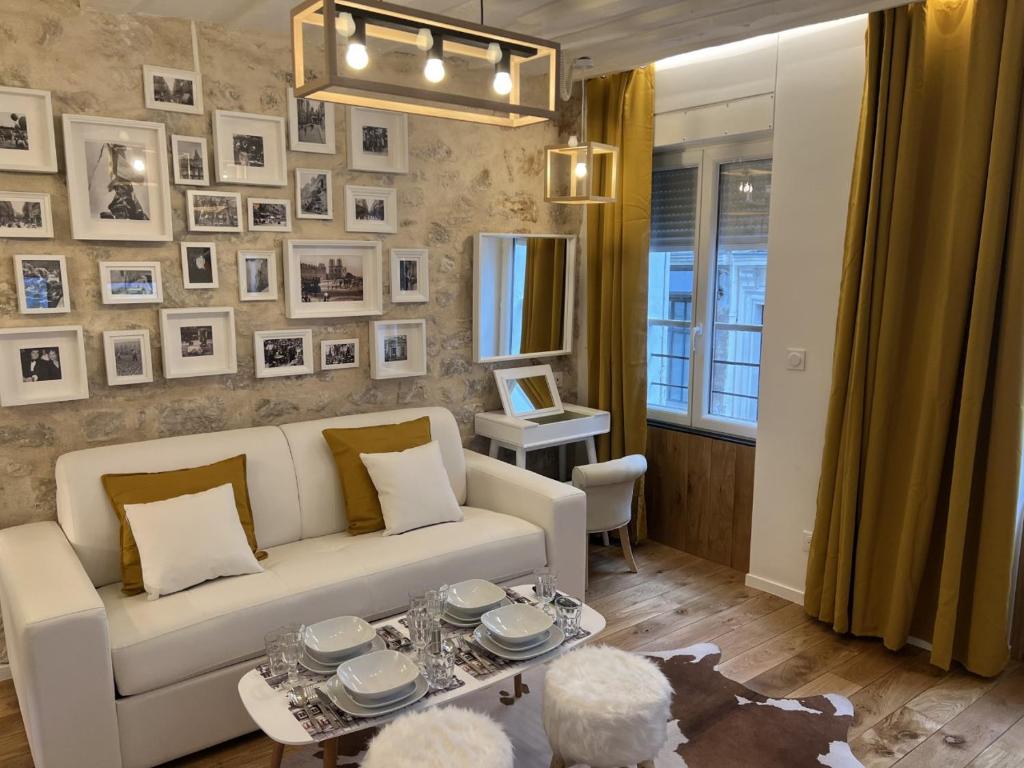a living room with a white couch and pictures on the wall at Villette & Canal - Apartment in Paris