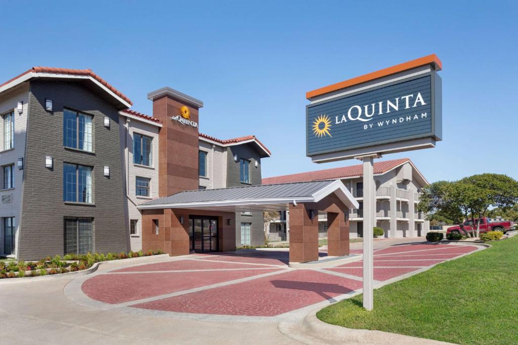 a sign for a hotel in front of a building at La Quinta Inn by Wyndham Temple in Temple