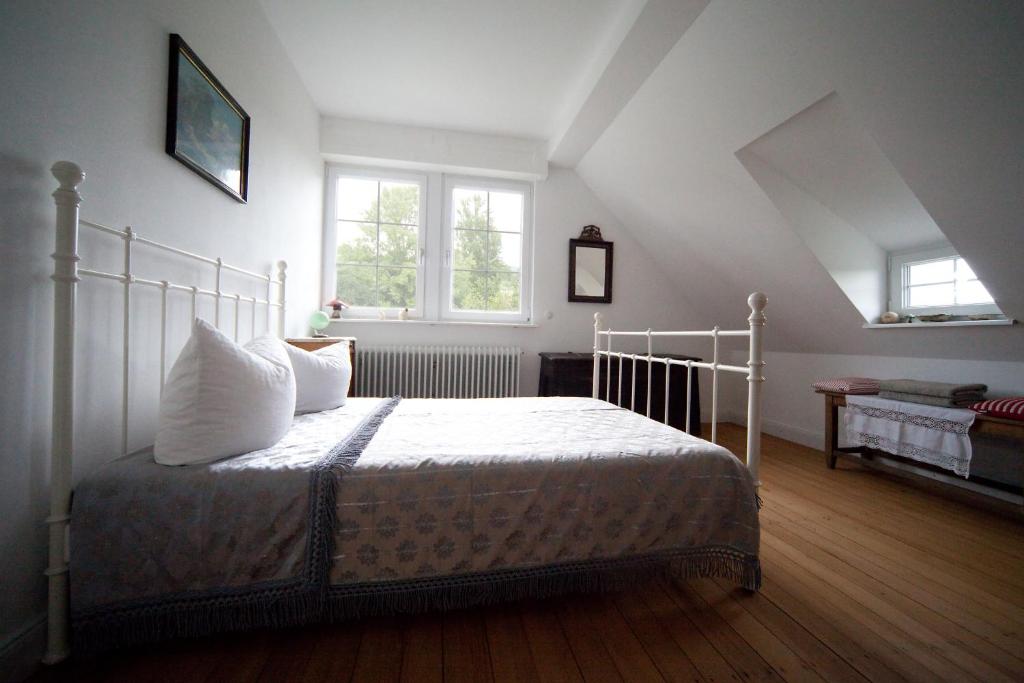 1 dormitorio con 1 cama con sábanas y almohadas blancas en Wohnen im alten Pfarrhaus, en Herbolzheim