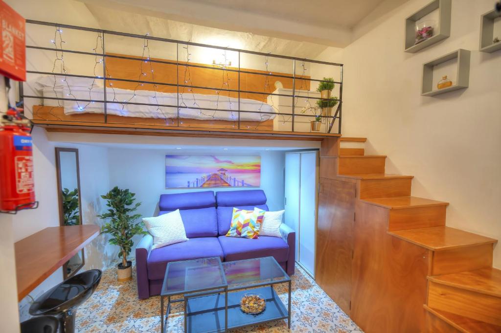 ein Wohnzimmer mit einem Sofa und einem Hochbett in der Unterkunft Cozy & cute studio in the heart of Valletta GOVAL2 in Valletta
