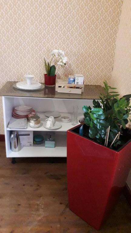 einem weißen Tisch mit einer Pflanze in einem roten Topf in der Unterkunft JEMISTANA 