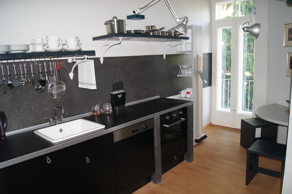 una cocina con encimera negra y fregadero en Altstadthaus Cityappartements, en Graz