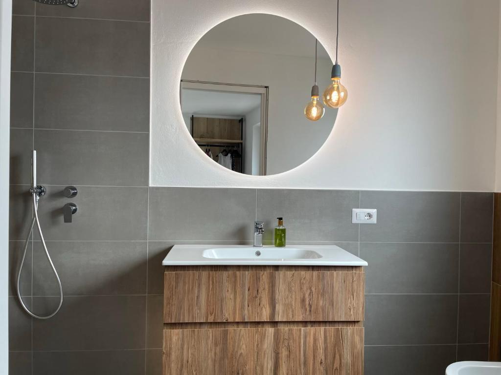ein Bad mit einem Waschbecken und einem Spiegel in der Unterkunft B&B NALÙ in Arco