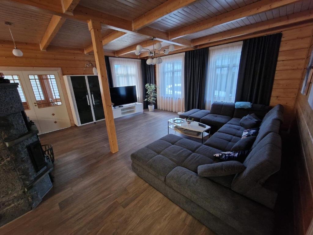 Baložu rezidence في يورمالا: غرفة معيشة مع أريكة وتلفزيون