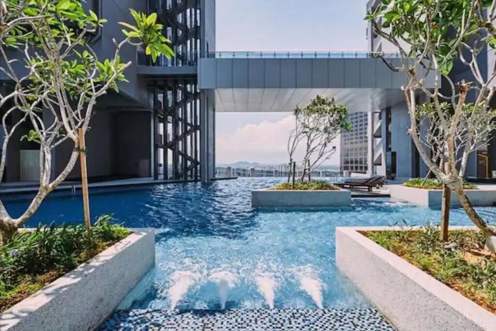 a swimming pool in the middle of a building with trees at Trevor bathtub Imperio residence seaview jonker5min in Melaka