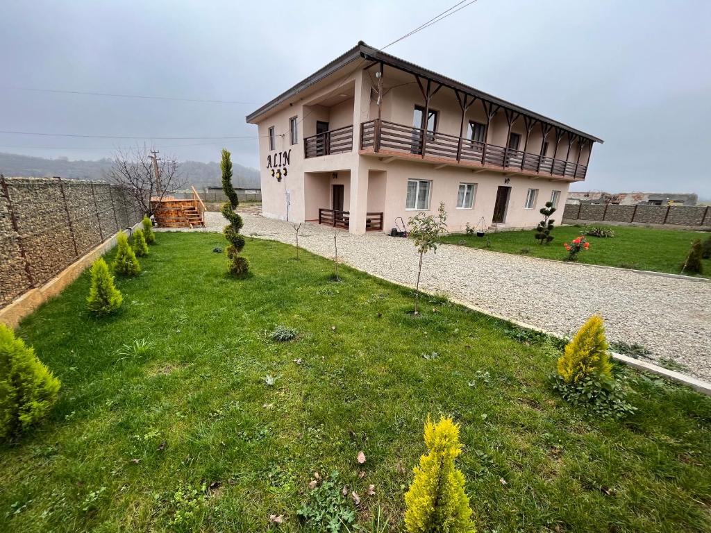uma casa numa colina com um jardim verde em Pensiunea Alin em Siseştii de Sus