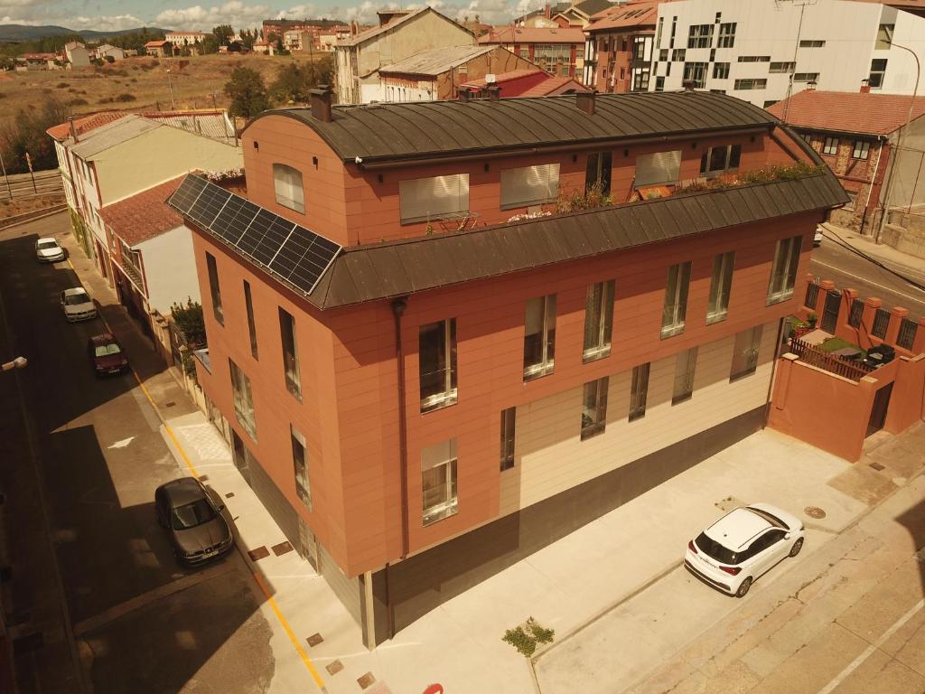 una vista aérea de un gran edificio de ladrillo con un coche aparcado fuera en El Roble 9 en Astorga