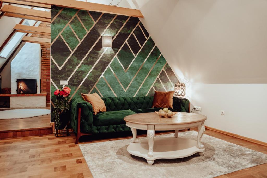a living room with a green couch and a table at Rataskaevu Boutique - 7 Unique Apartments in Tallinn