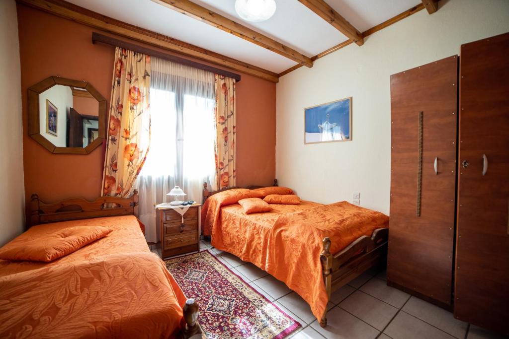1 dormitorio con 2 camas y espejo en Mprizis Rooms en Elati Trikalon
