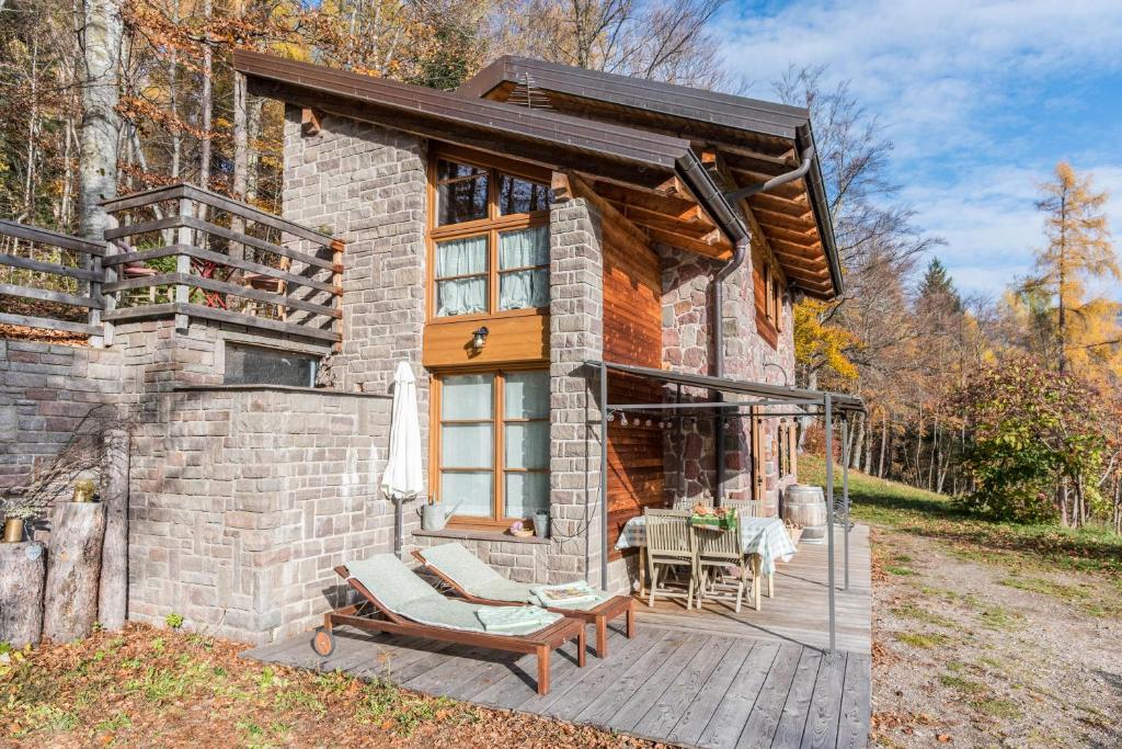 una piccola casa in pietra con portico e ponte di Baita Al Rossat a Sant’Orsola