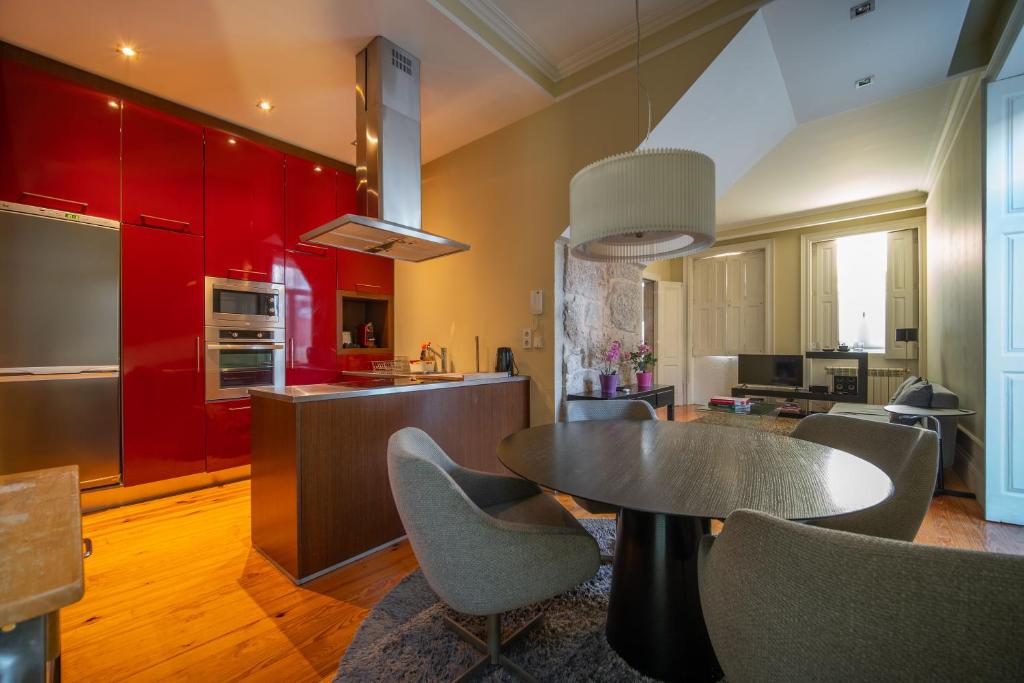 eine Küche mit roten Schränken sowie einem Tisch und Stühlen in der Unterkunft Oporto Near Boavista in Porto