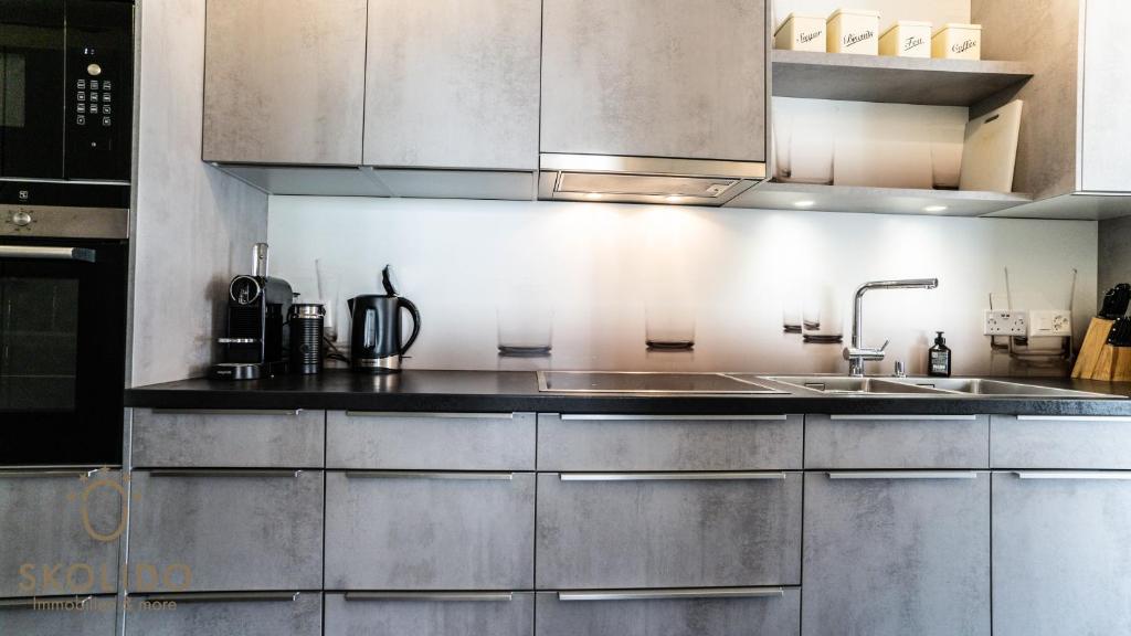 a kitchen with stainless steel cabinets and a sink at Haus Camillo in Saas-Fee