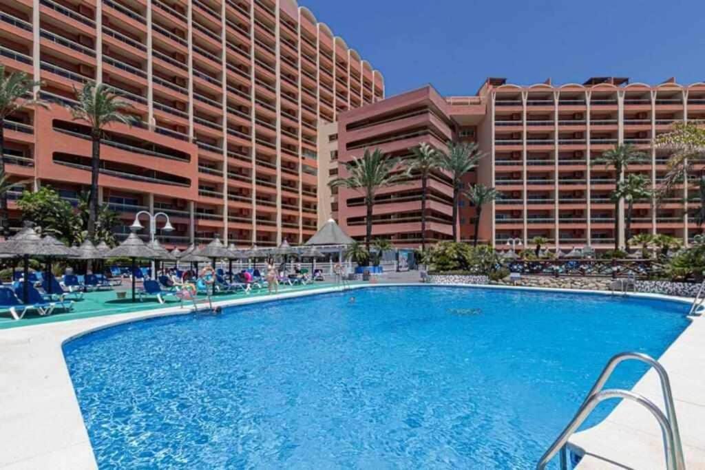 a large swimming pool in front of a hotel at 797 Holiday Rentals- Apartamento en Hotel Sunset Beach frente al mar in Benalmádena