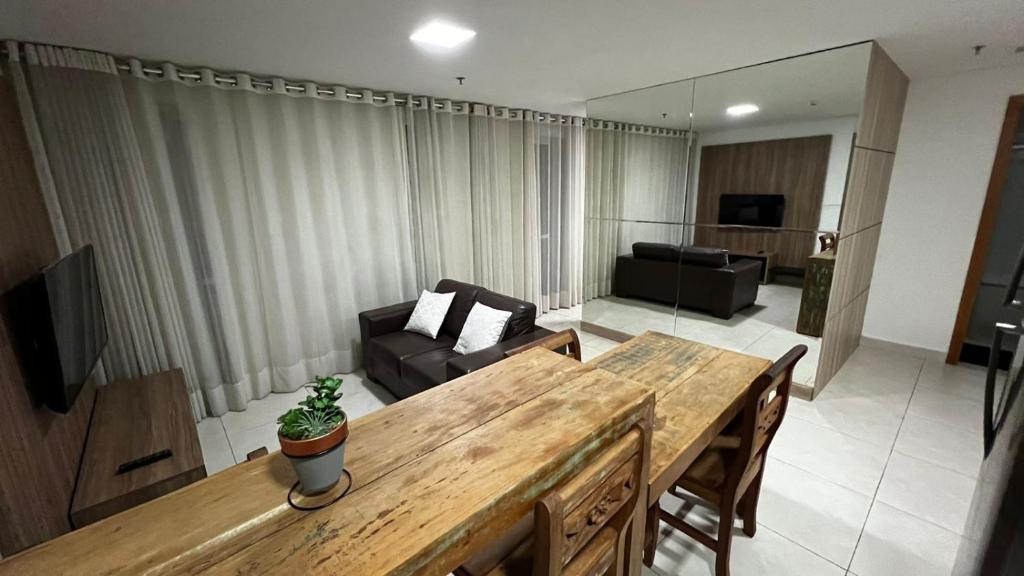 ein Wohnzimmer mit einem Tisch und einem Sofa in der Unterkunft Flat Brookfield Towers 2309 in Goiânia