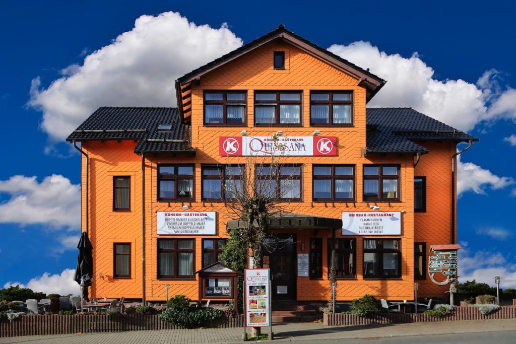 ein orangefarbenes Gebäude mit einem Schild davor in der Unterkunft Konsum Gästehaus Quisisana - Nebenhaus Berghotel Oberhof - nur Übernachtung in Oberhof