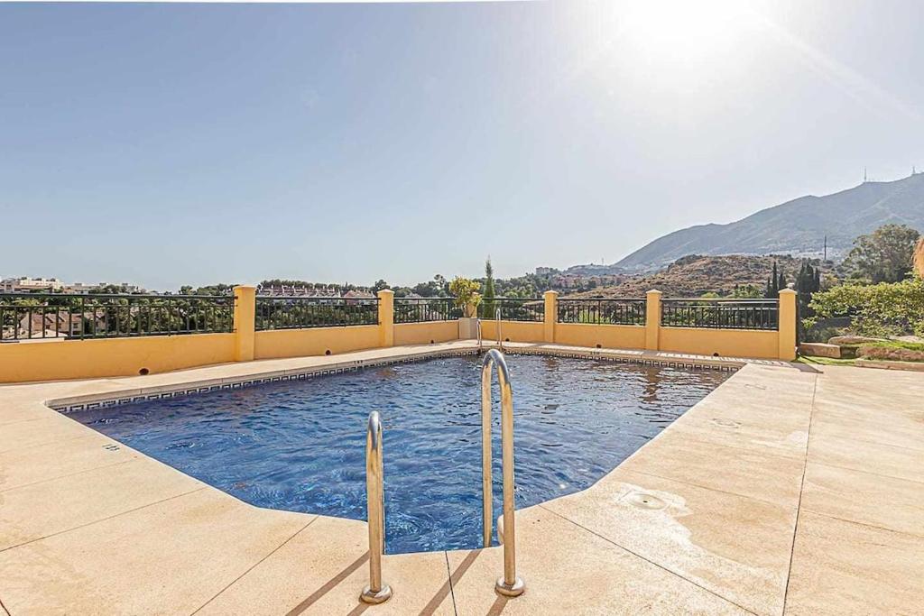 basen z żółtym płotem i góry w obiekcie 797 HOLIDAY RENTALS - Moderno Piso para 5 con hermosas vistas w mieście Benalmádena