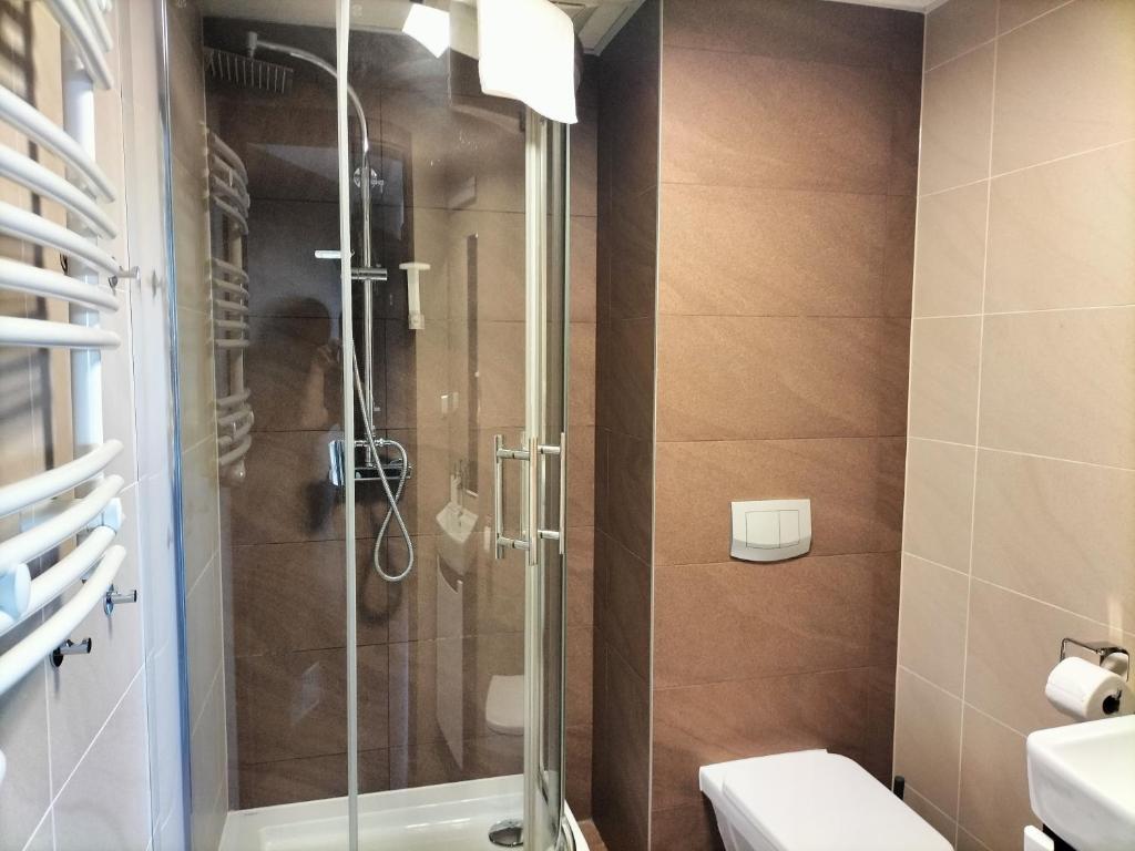 a bathroom with a shower and a toilet at Hotel ŚWIT in Krakow