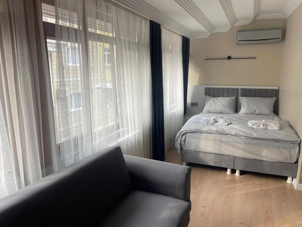 a bedroom with a bed and a couch and windows at Blue Mosque Apart in Istanbul