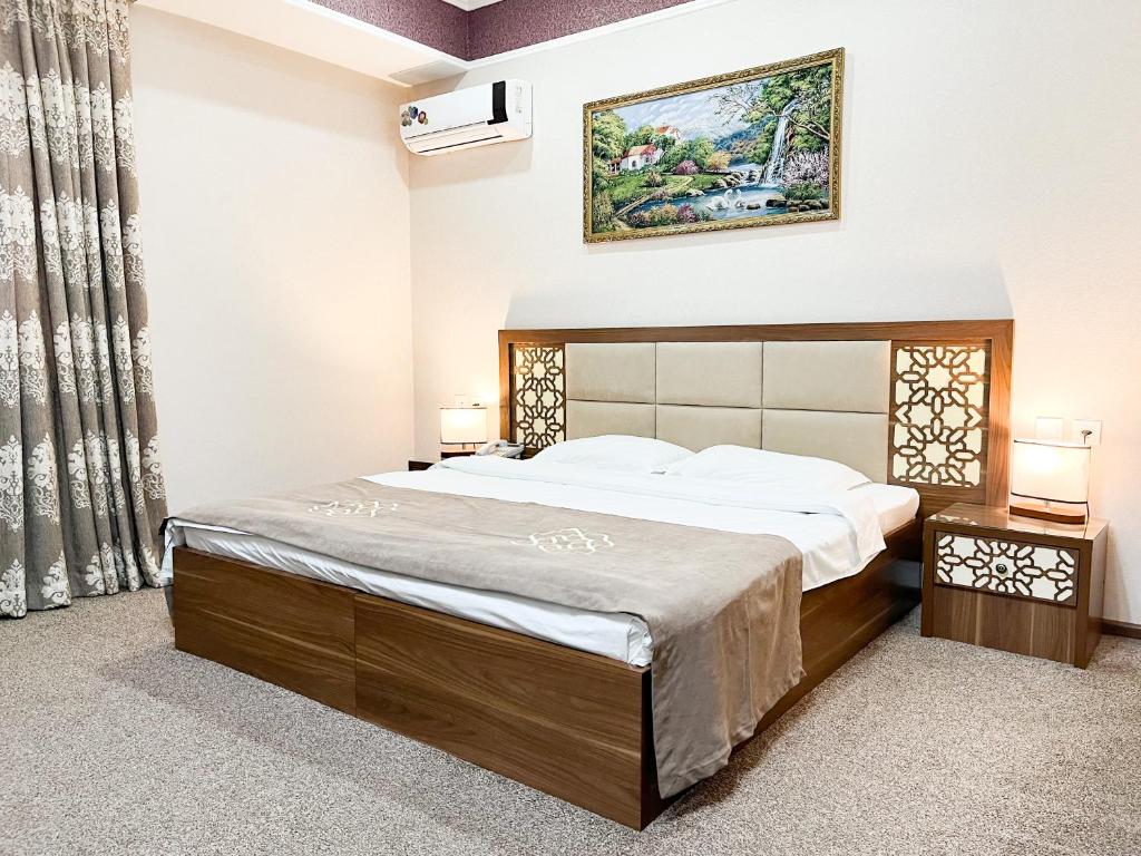 1 dormitorio con 1 cama y una foto en la pared en Reikartz Xon Tashkent, en Tashkent