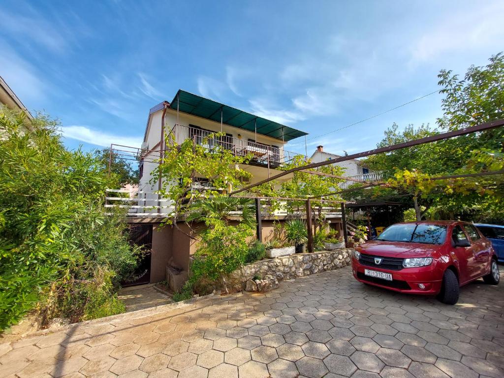 a red car parked in front of a building at Apartments Vilim in Pinezici