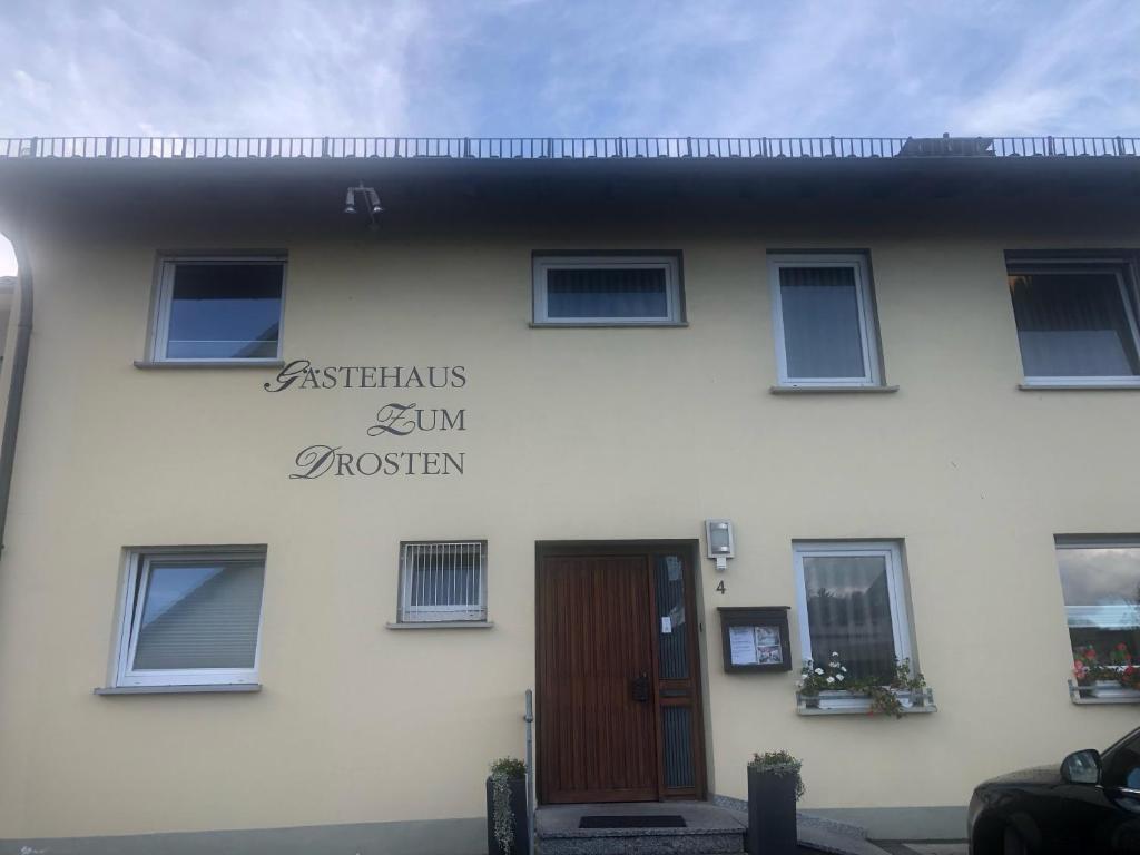 a white building with a sign on the side of it at Hotel garni Zum Drosten in Balve