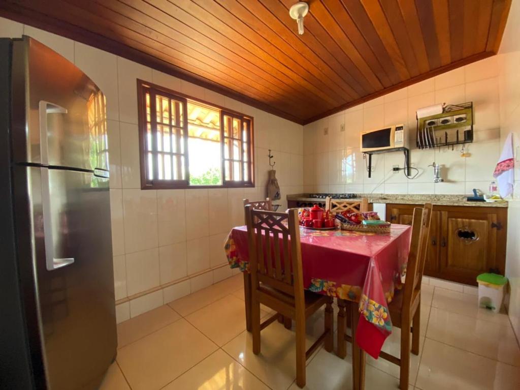 a kitchen with a table with a red table cloth at Aconchego de Regina in Tiradentes