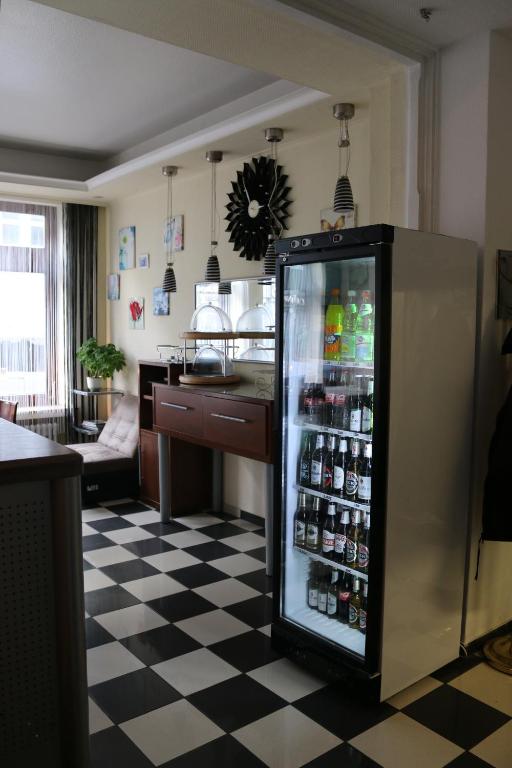 a refrigerator filled with lots of drinks on a checkered floor at Hotel Berliner Hof in Düsseldorf