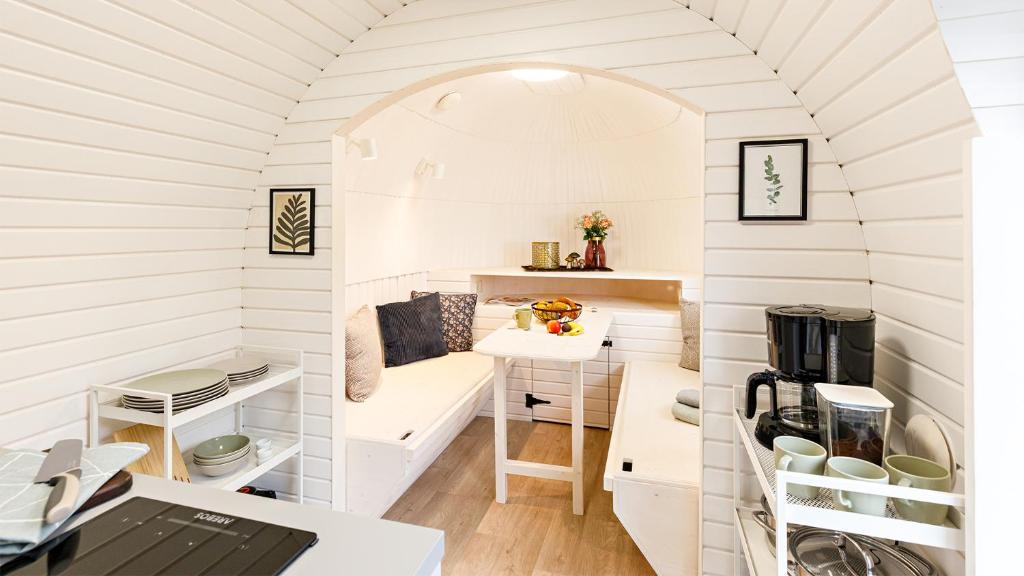 een tiny house met een boog en een bureau bij Auszeitgarten - Urlaub im Tinyhaus im Herzen von Oberschwaben in Aulendorf